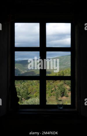 Paesaggio montano visto attraverso la cornice di una finestra chiusa in una casa di campagna Foto Stock