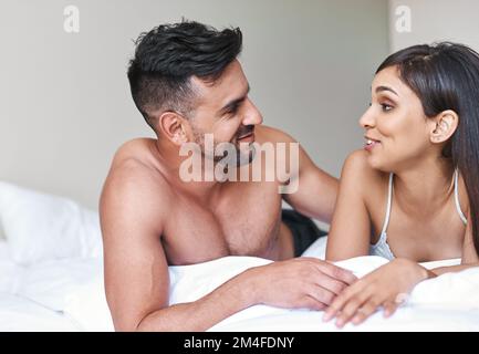 Discussioni mattutine per ottenere la mente andare. una giovane coppia sposata affettuosa a letto a casa. Foto Stock