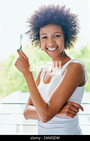 Non affrettatevi mai quando dovete spazzolare i denti. una giovane donna attraente che si sfrega i denti nel bagno a casa. Foto Stock