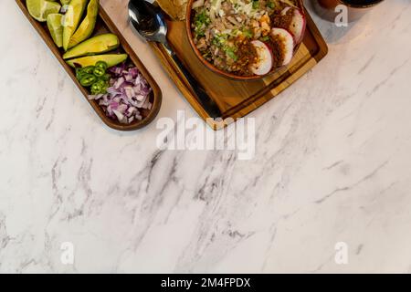 cipolla tritata per piatto con carne nel suo succo, con avocado e crudo cileno verde Foto Stock