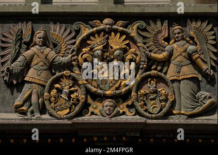 Gli angeli dalla facciata grimosa supportano elaborati dispositivi araldici dorati sopra il portale rinascimentale dei primi anni '1600s scolpito sulla facciata della Haus zum Goldenen Ochsen (Casa dell'Ox d'Oro) a Vorstadt 17 nella città vecchia di Schaffhausen, nel nord della Svizzera. L'ex locanda è stata trasformata in un'elegante residenza per la famiglia Hageloch nel 1608-9, completa di facciata affrescata. Foto Stock