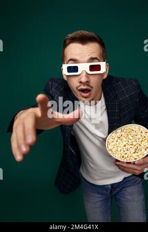 uomo in 3d bicchieri che tiene un grande secchio di popcorn Foto Stock