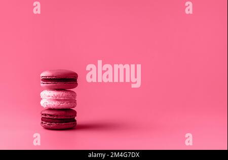 Tre amaretti in stack tonati in color magenta trendy dell'anno 2023. Concetto di cibo. Spazio di copia. Primo piano. Foto Stock