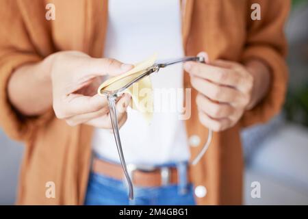 Pulizia di occhiali, stoffa e mani di donna facendo la cura degli occhi con tessuto per pulire lenti e telaio. Polvere, sporcizia e cura di una persona all'optometro o al medico Foto Stock