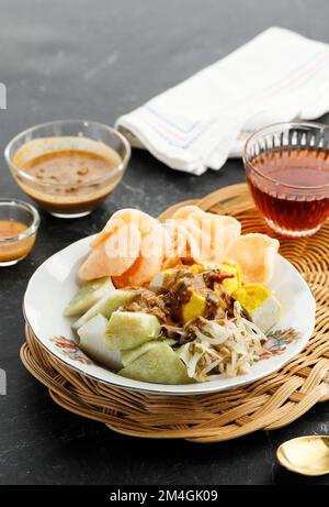 Ketoprak o Kupat Tahu, torta di riso compresso o Lontong servito con tofu, germoglio di fagioli bolliti, Karupuk e salsa di arachidi. Cibo di strada indonesiano per Fr Foto Stock