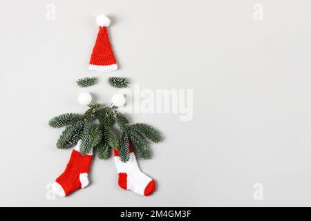 Concetto minimo di Babbo Natale. Composizione creativa di Natale. Cappello di Babbo Natale, barba fatta di rami di albero di Natale Foto Stock