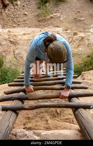 Durante una visita estiva, il visitatore sale sulla scala delle rovine di Mesa Verde Foto Stock