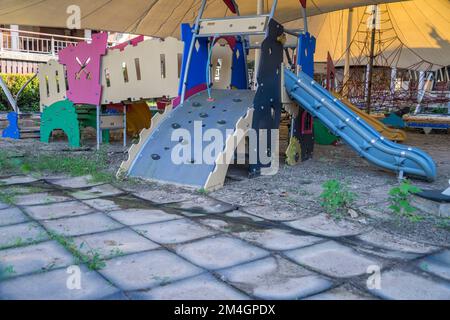 Un parco giochi abbandonato in serata, visto dalla terra sterrata a Chiangmai Thailandia. Foto Stock