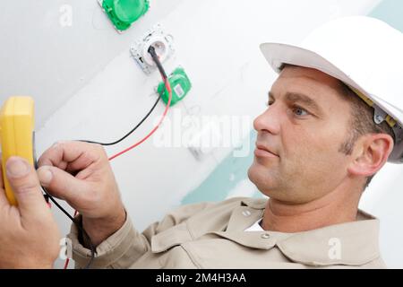 primo piano di un tecnico maschile che esegue la lettura del misuratore utilizzando il telefono cellulare Foto Stock