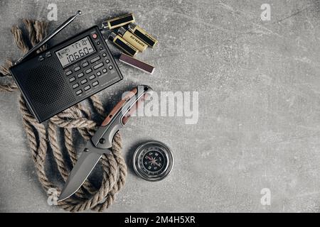 Coltello tattico pieghevole per sopravvivenza, radio, corda, fiammiferi, batterie e bussola, kit di sopravvivenza in condizioni difficili Foto Stock