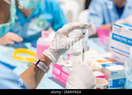 Un funzionario sanitario preleva una dose da un flacone di vaccino Covid-19 predisposto presso il centro di vaccinazione. Foto Stock