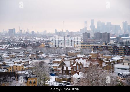 Vista aerea dei tetti di Londra ricoperti di neve; Canary Warf sullo sfondo Foto Stock