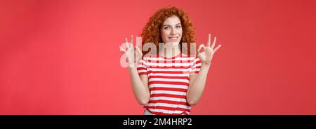 Fine relax tutto perfetto. Soddisfatto buon aspetto redhead allegro ragazza sassy curiosamente haristyle mostra OK confermare gesto sorridente approvazione Foto Stock