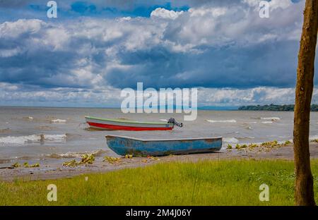 Due barche da pesca parcheggiate sulla riva di un lago, Nicaragua. Concetto di due barche da pesca parcheggiate sulla riva del mare, due barche da pesca in legno sul Foto Stock