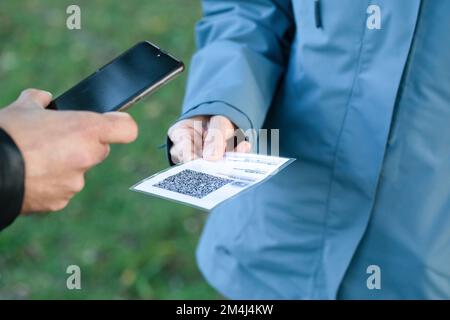 primo piano delle mani durante il controllo del passaporto verde con l'applicazione per smartphone. Concetto di sicurezza e prevenzione contro il COVID-19 Foto Stock