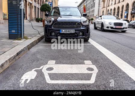 Mini auto elettrica, veicolo elettrico, ricarica di veicoli elettrici presso la stazione di ricarica, logo, auto di lusso di passaggio, Maximilianstrasse, Monaco di Baviera, Superiore Foto Stock