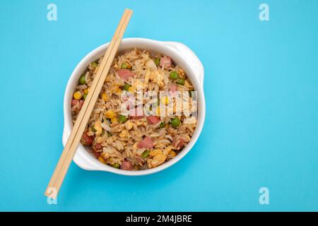 Riso con mais. piselli, prosciutto su ciotola bianca piccola Foto Stock