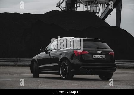 Un'Audi Q7 nera e brillante con montagne sullo sfondo Foto Stock