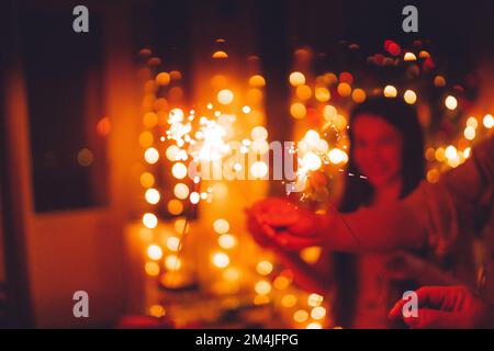 Brillante Natale festivo o Capodanno scintillante in mano tonificante, gruppo di amici che festeggiano insieme. Foto Stock