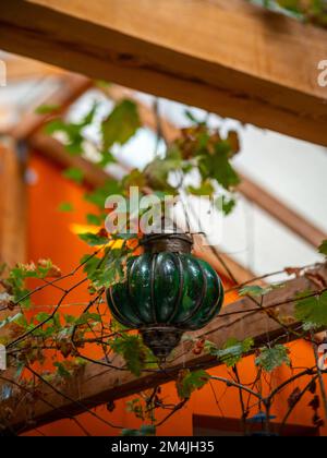 Primo piano di una lanterna d'epoca appesa e decorativa con vetro verde. Foto Stock