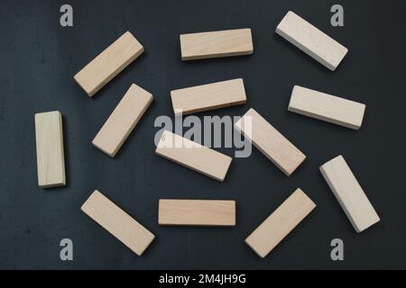 blocchi di legno allineati in file su sfondo nero Foto Stock