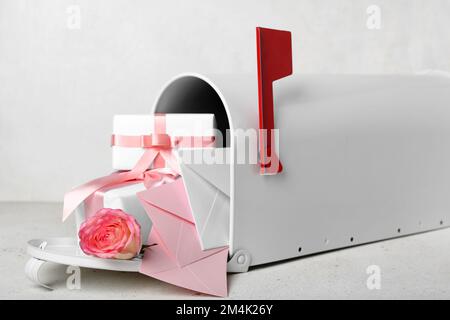 Mailbox con lettere, regali e rosa su sfondo bianco. Festa di San Valentino Foto Stock