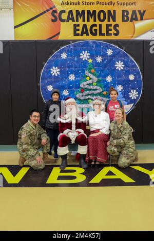 Scammon Bay, Stati Uniti d'America. 16 Novembre 2022. Babbo Natale e Mrs Claus posano con i membri della Guardia Nazionale aerea dell'Alaska e i bambini durante l'operazione Babbo Natale al centro della comunità di Scammon Bay, 16 novembre 2022 a Scammon Bay, Alaska. Babbo Natale e Mrs Claus con l'aiuto della Guardia Nazionale e dell'Esercito della salvezza, forniscono regali di Natale, libri, forniture scolastiche e omaggi ai giovani delle remote comunità rurali dell'Alaska. Credit: Alaska Air Guard/National Guard/Alamy Live News Foto Stock