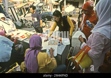 Le donne stanno preparando un concorso di colorazione per bambini nella zona di Gegerkalong, centro delle attività di Daarut Tauhiid, un'istituzione islamica fondata dal famoso predicatore islamico indonesiano, KH Abdullah Gymnastiar, situato a Bandung, Giava Occidentale, Indonesia. Gymnastiar (popolarmente noto come AA Gym), Daarut Tauhiid, e il loro ramo di gestione Manajemen Qolbu (mq), sono riusciti a intensificare il turismo religioso e le attività economiche nella zona di Gegerkalong a Bandung City. Foto Stock