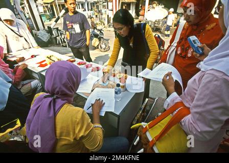 Le donne stanno preparando un concorso di colorazione per bambini nella zona di Gegerkalong, centro delle attività di Daarut Tauhiid, un'istituzione islamica fondata dal famoso predicatore islamico indonesiano, KH Abdullah Gymnastiar, situato a Bandung, Giava Occidentale, Indonesia. Gymnastiar (popolarmente noto come AA Gym), Daarut Tauhiid, e il loro ramo di gestione Manajemen Qolbu (mq), sono riusciti a intensificare il turismo religioso e le attività economiche nella zona di Gegerkalong a Bandung City. Foto Stock