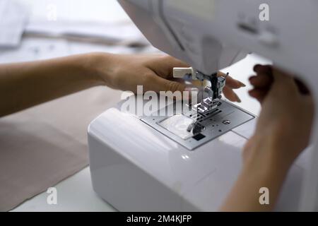 Camera stilista, il sarto sta verificando l'autenticità della macchina da cucire. Primo piano Foto Stock