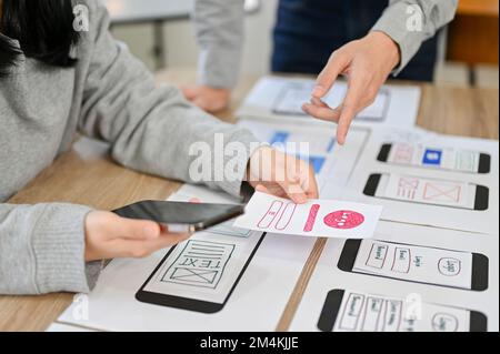 Immagine ritagliata, Un team di progettisti di interfacce per applicazioni mobili è impegnato nella riunione, nella pianificazione e nella progettazione delle applicazioni. Foto Stock