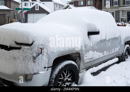 Un'auto sotto la neve. Scena urbana invernale in Canada. Veicoli coperti di neve in inverno Blizzard nel parcheggio. Auto in snowdrifts dopo uno snowf Foto Stock