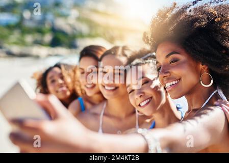 Sei pronto per l'estate come noi. un gruppo di giovani donne felici che prendono selfie insieme in spiaggia. Foto Stock