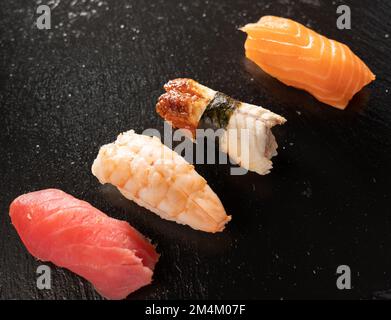 primo piano del sushi sashimi impostato su sfondo nero. Cibo giapponese Foto Stock