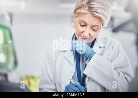 Scienza, ricerca e donna anziana scrivendo note su documenti in laboratorio. Innovazione, pensiero e ricerca di scienziato femminile anziano, registrazione Foto Stock