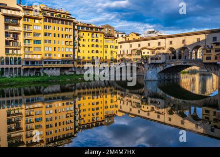 Coloratissime riflessioni dell'elevazione orientale del Ponte Vecchio e degli edifici sulla sponda sud dell'Arno all'alba a Firenze, Toscana, Italia Foto Stock