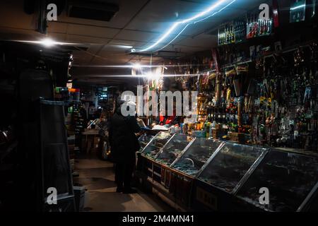 Kiev, Ucraina. 14th Dec, 2022. Un uomo che vende gli attrezzi ai clienti è visto dietro il bancone di un bazar di Kyiv in un blackout. A seguito di massicci attacchi missilistici contro l'infrastruttura elettrica dell'Ucraina da parte della Russia, più del 50% del consumo del sistema energetico unificato del paese è stato perso, ha affermato la National Energy Company (NPC) Ukrenergo.secondo il codice del sistema di trasmissione, La perdita di oltre il 50% del consumo determina l'inizio della modalità incidente del sistema (Credit Image: © Mykhaylo Palinchak/SOPA Images via ZUMA Press Wire) Foto Stock