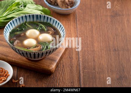 Mangiare il grande tangyuan yuanxiao (tang yuan, palle glutinose di riso gnocchi) con una zuppa saporita in una ciotola per il festival del solstizio d'inverno. Foto Stock