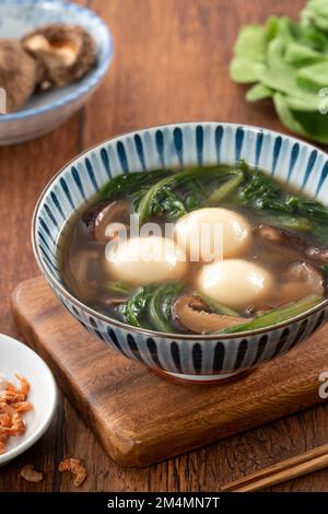 Mangiare il grande tangyuan yuanxiao (tang yuan, palle glutinose di riso gnocchi) con una zuppa saporita in una ciotola per il festival del solstizio d'inverno. Foto Stock