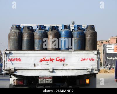 Cairo, Egitto, dicembre 21 2022: Bombole di butano e gas su un veicolo di trasporto per il trasporto e la distribuzione al Cairo, traduzione di arabo Foto Stock