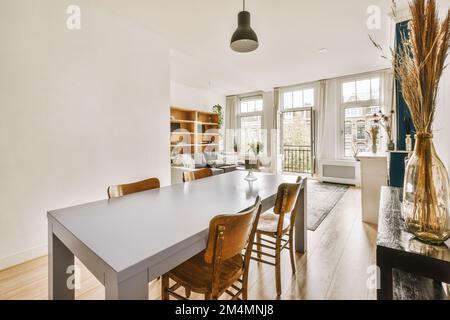 un soggiorno con pareti verdi e pavimento bianco, che include un tavolo da  pranzo in legno circondato da due sedie colorate Foto stock - Alamy