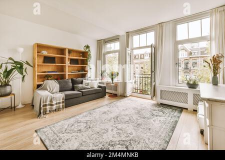 un soggiorno con pavimento in legno e grandi finestre che si affacciano sul cityscapeatrooms com Foto Stock