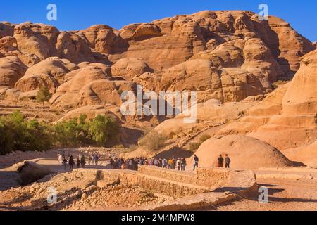 Petra, Giordania - 3 novembre 2022: Persone turisti che camminano lungo canyon di arenaria, formazioni rocciose nel sito patrimonio dell'umanità dell'UNESCO Foto Stock