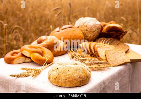 lotto di pane, grano, segale aromatizzato, sulla tavola all'esterno del campo Foto Stock