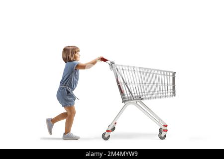 Profilo a lunghezza intera girato di una bambina che spinge un grande carrello vuoto isolato su sfondo bianco Foto Stock