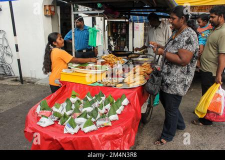 Georgetown, Penang, Malesia - Novembre 2012: Una ragazza che vende spuntini indiani fritti in profondità in una bancarella di falegname a Little India a George Town, Penan Foto Stock