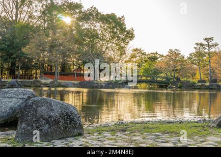 Splendido panorama di luci ombreggiate nel laghetto di Sanja Takusen con vecchio ponte in stile giapponese sullo sfondo a Nara Park, Giappone. Foto Stock