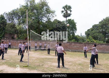 Studenti di scuola che giocano a pallavolo nel parco giochi della scuola foto d'archivio Foto Stock