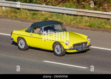 1975 70s, settanta Yellow MG B MGB, una vettura sportiva a due porte, prodotta e commercializzata dal 1962 al 1980 dalla British Motor Corporation (BMC) 1798cc benzina British SPORTS Cabrio, viaggiando sull'autostrada M6 UK Foto Stock