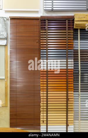 Campioni di tende per finestre nel negozio. Tende in plastica, tende pieghettate, avvolgibili e tende diurne e notturne in negozio. Foto Stock